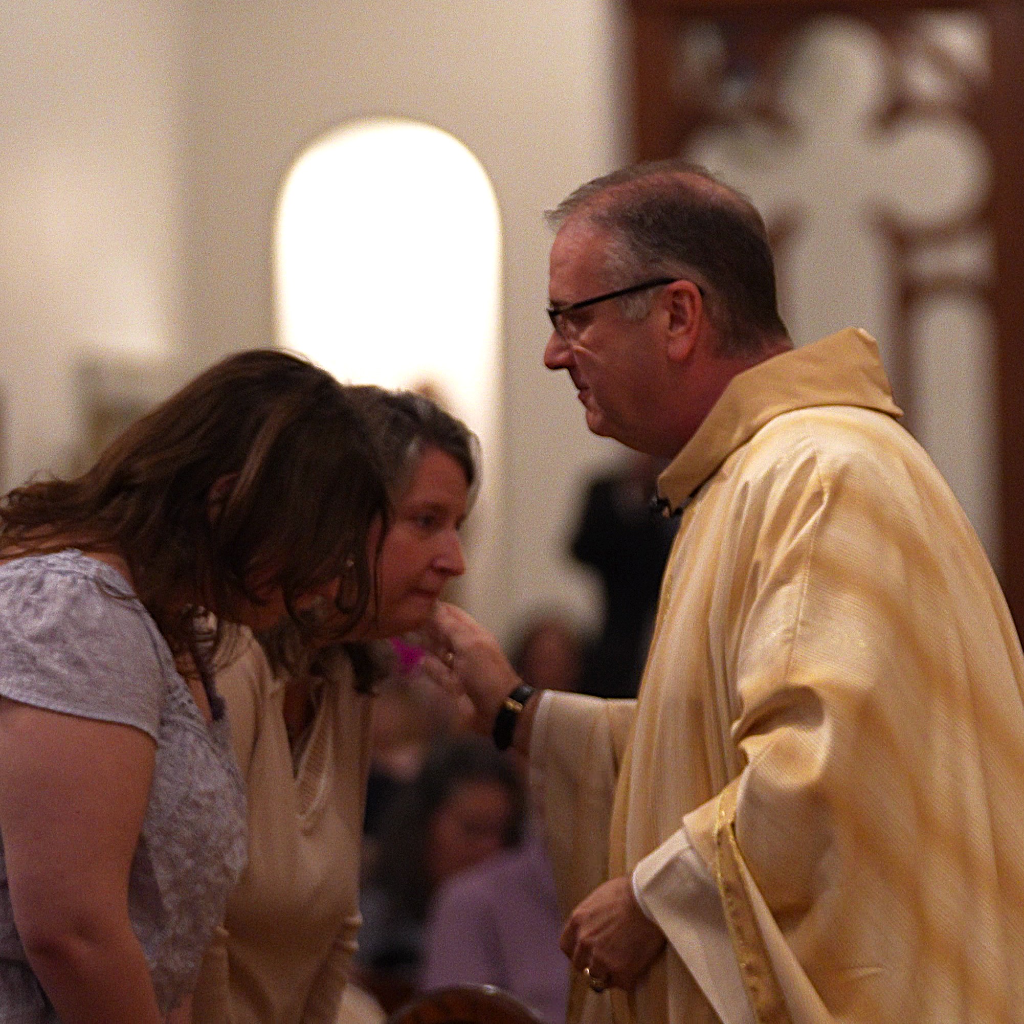 Event videography still of a clergy member with family at a ceremony celebrating his 25th ordination anniversary in the Triangle, NC