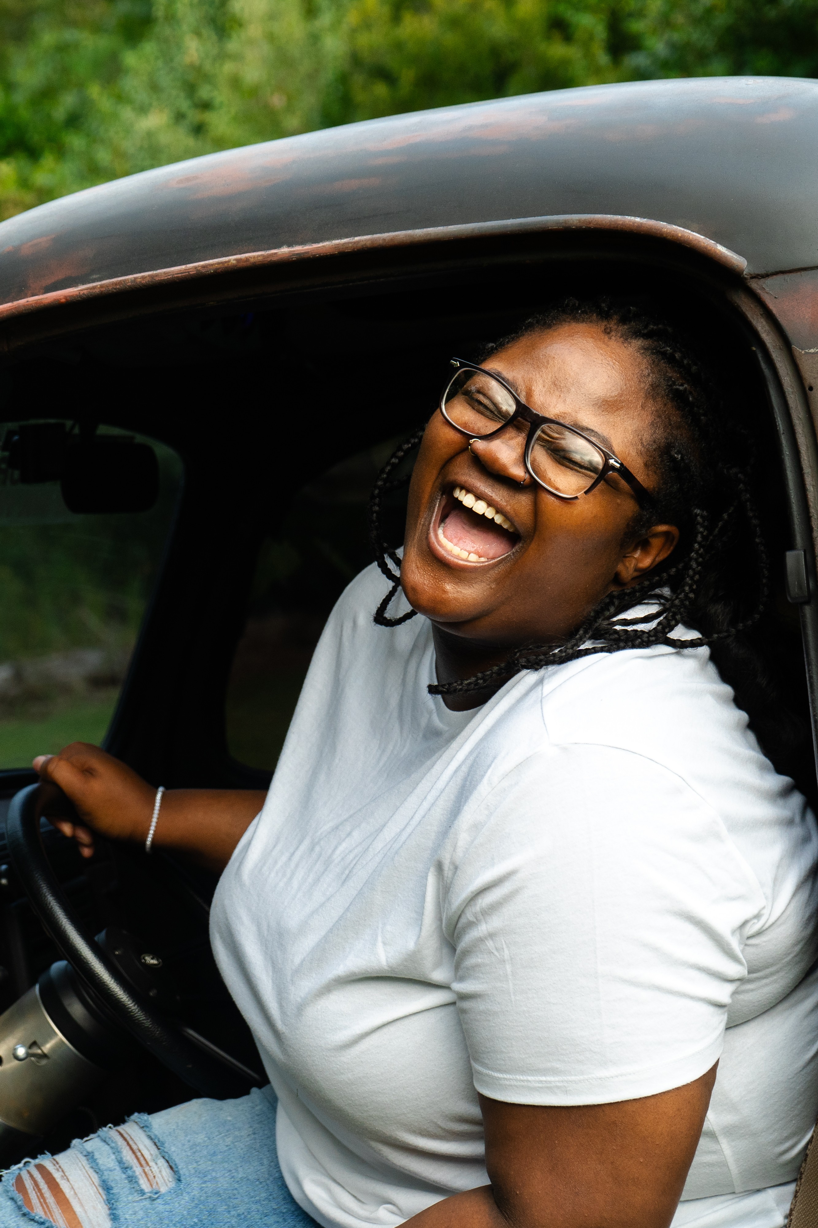 Lifestyle portrait of a woman laughing in a vintage truck