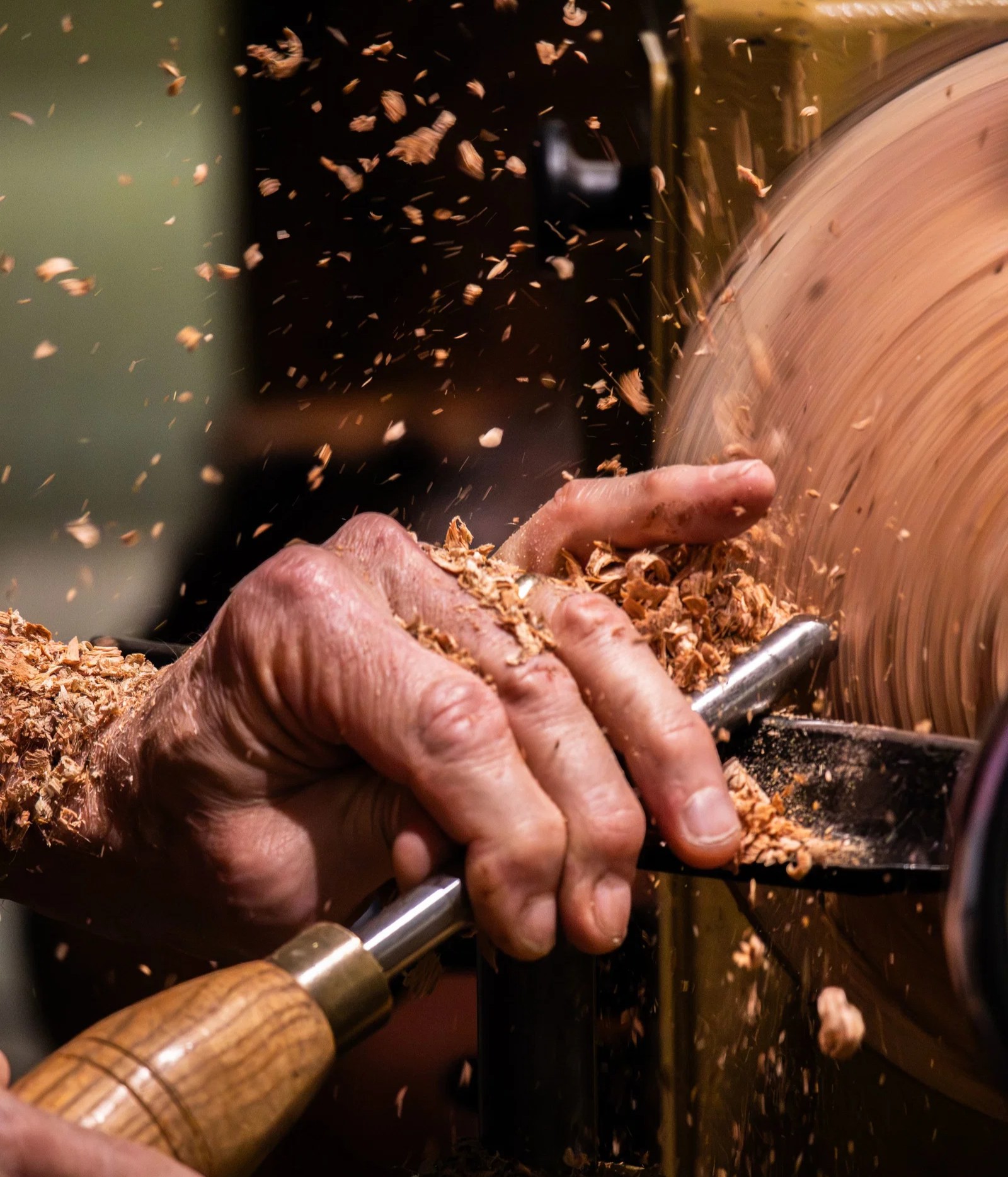 Brand photography of an artisan turning a wooden bowl on a lathe