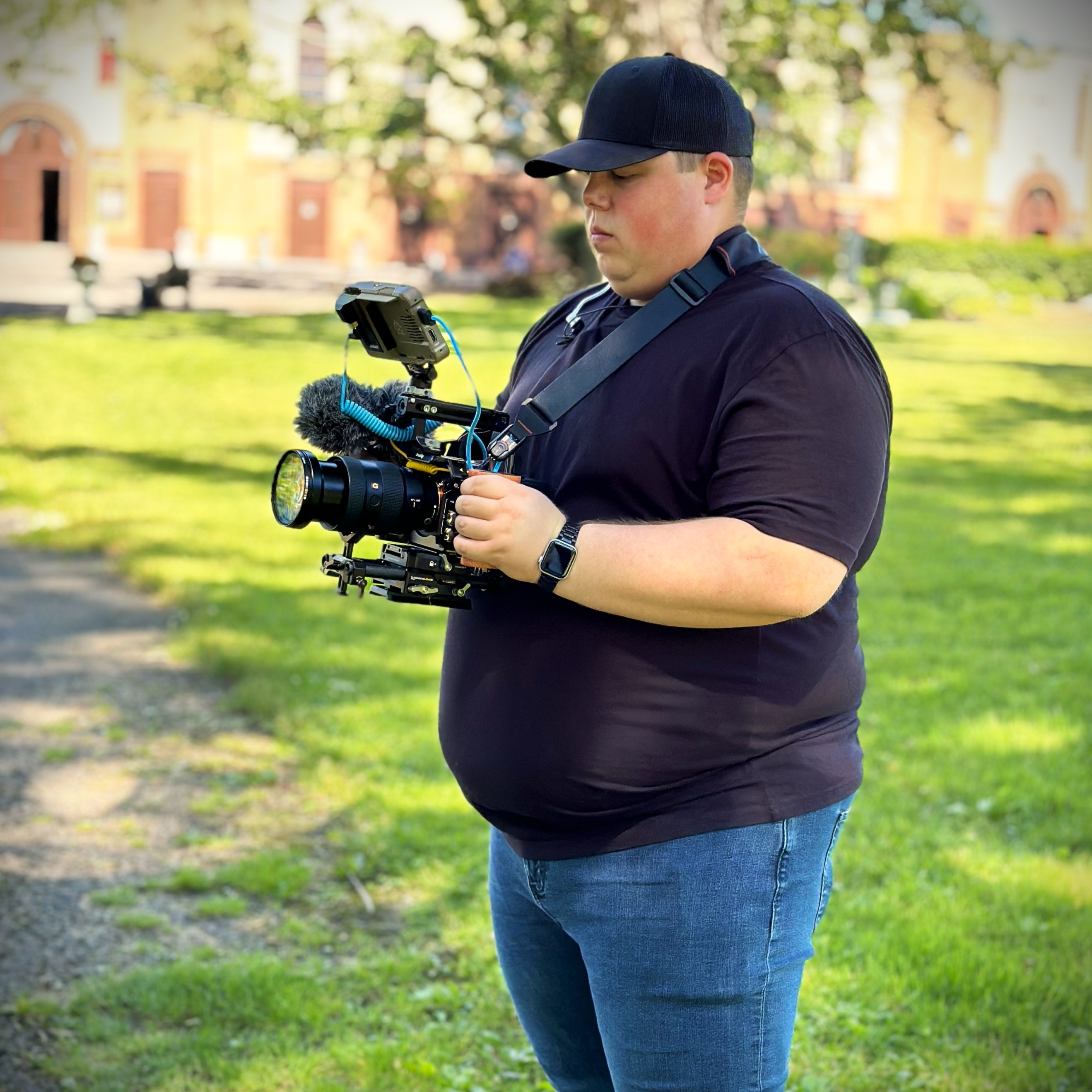Videographer Clayton Causer operating a cinema camera rig on a video production shoot in the Triangle, NC