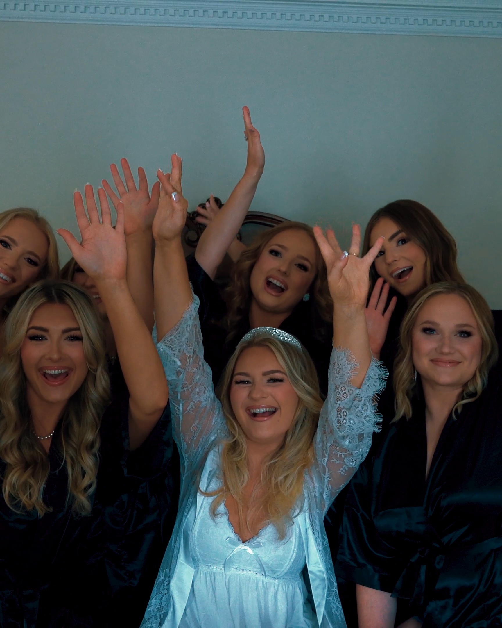 Bride and bridesmaids celebrating while getting ready on the wedding day